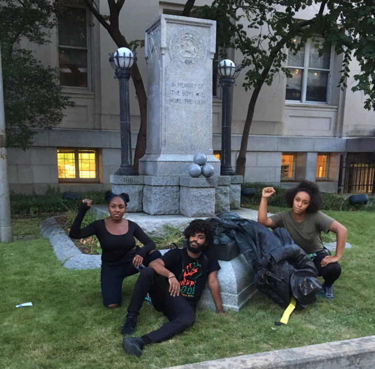 Durham, N.C. residents pose with toppled statue of a Confederate soldier. | Photo: Twitter / @DerrickQLewis